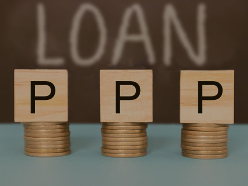 Text displaying PPP Loan on stacks of coins.